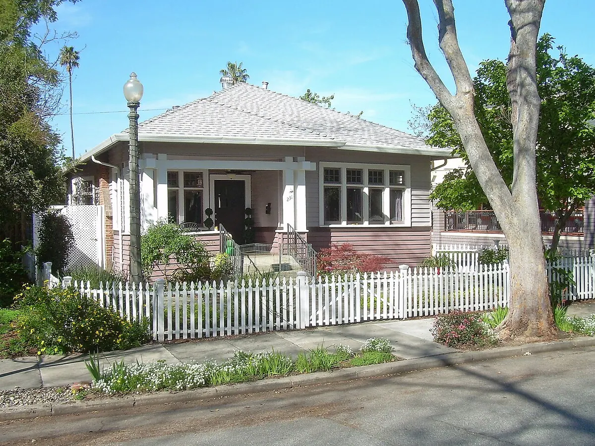 Craftsman bungalow with a hipped roof and a white picket fence (photographed in San Jose, California)