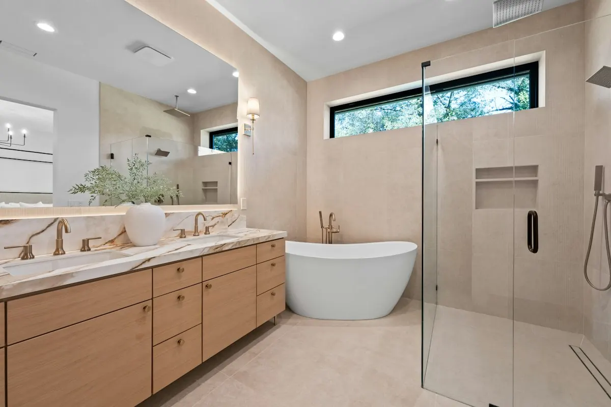 Bathroom with a long wood double vanity, a freestanding tub and a glass walk-in shower