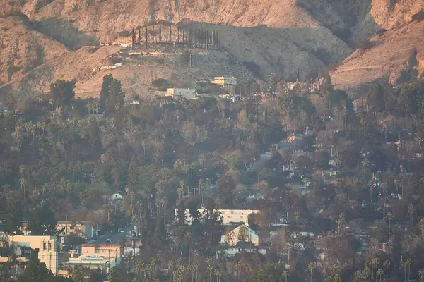 Burned hillside homes in Altadena after the January 2025 Eaton Fire, with standing houses below