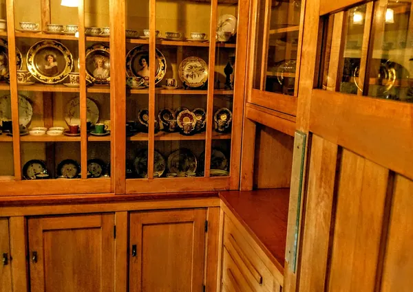 Built-in wood cabinets with glass doors over a checkered floor in a Craftsman house