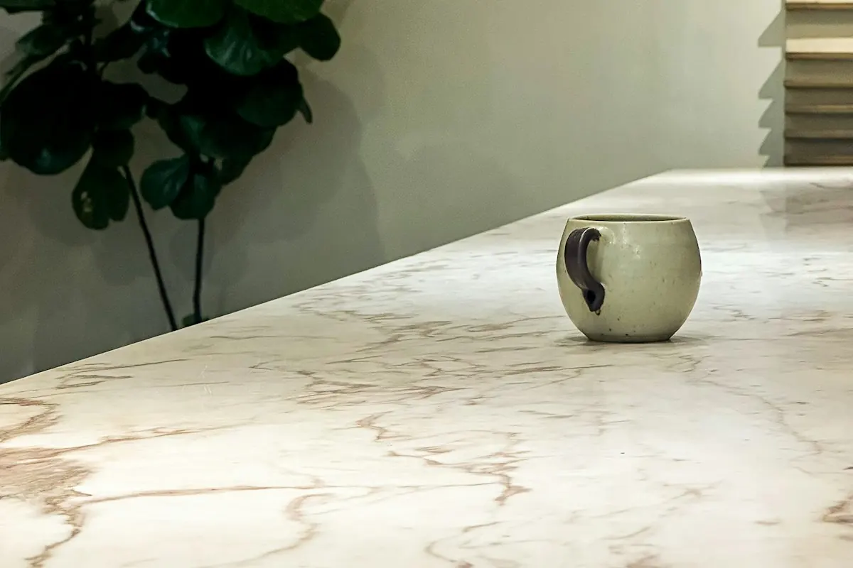 Close view of a veined white marble countertop with a single mug on it