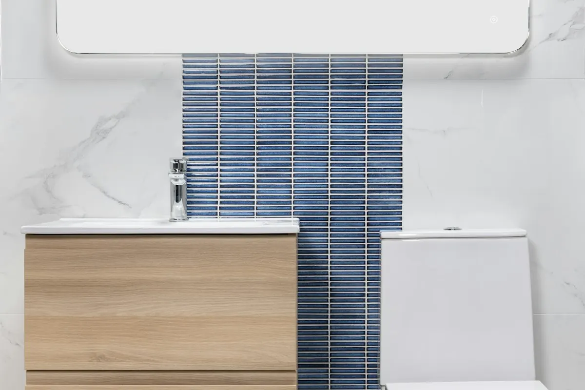 Small bathroom with a wall-hung wood vanity, a toilet and a vertical strip of blue tile